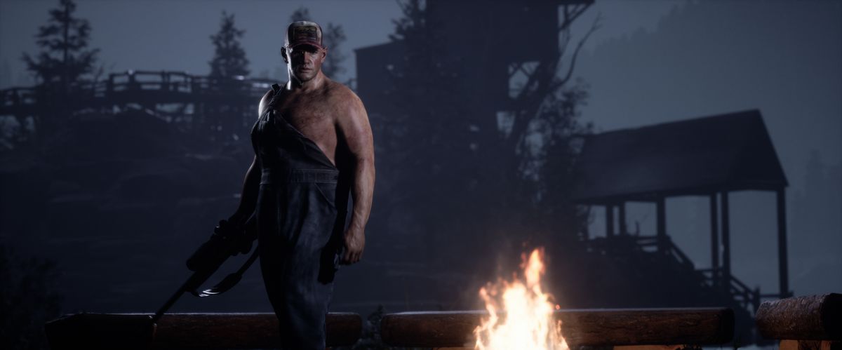Un uomo di nome Bobby si trova accanto a un fuoco che brandisce un fucile in uno screenshot di The Quarry