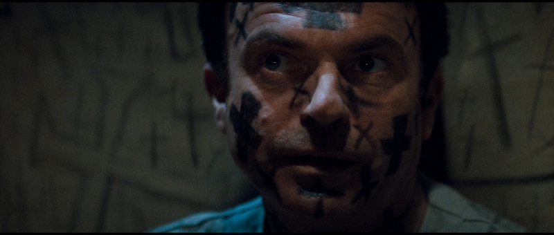 Sam Neill sta passando un brutto periodo in In the Mouth of Madness, con le croci appuntite sulla faccia.