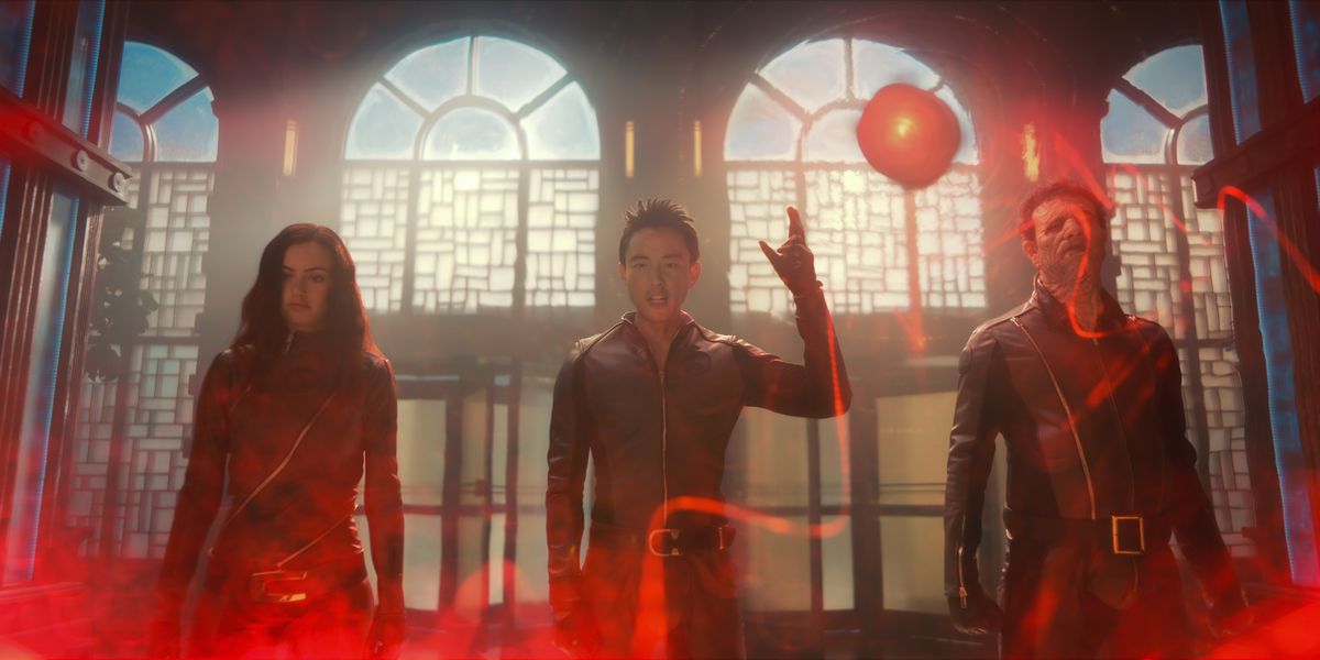 Jayme, Ben e Alphonso circondati da un'inquietante luce rossa, mentre indossano abiti rossi in spandex