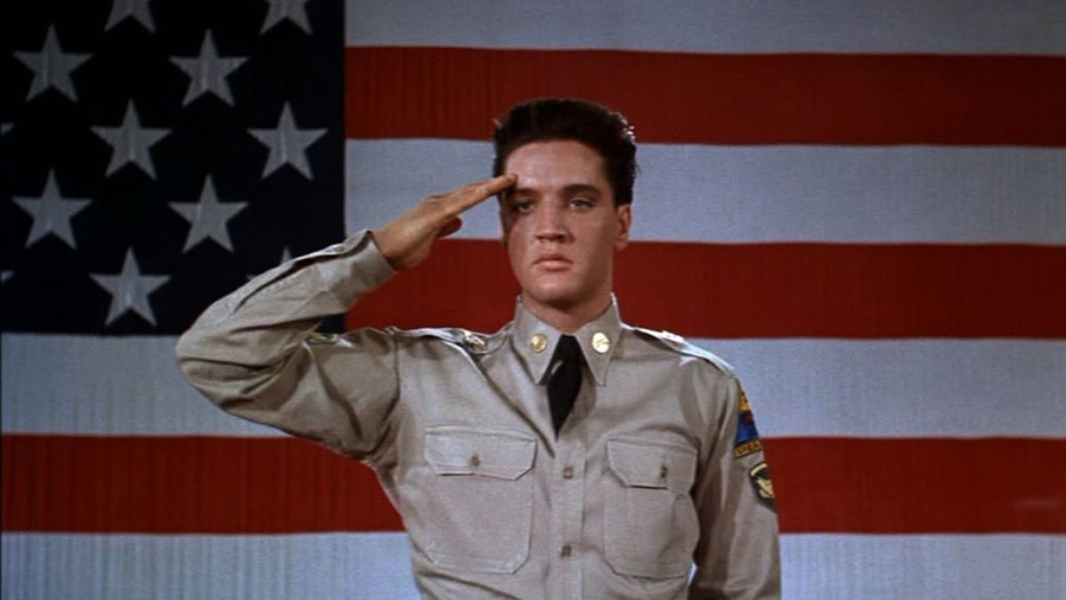 Elvis saluta davanti a una bandiera americana in GI Blues.