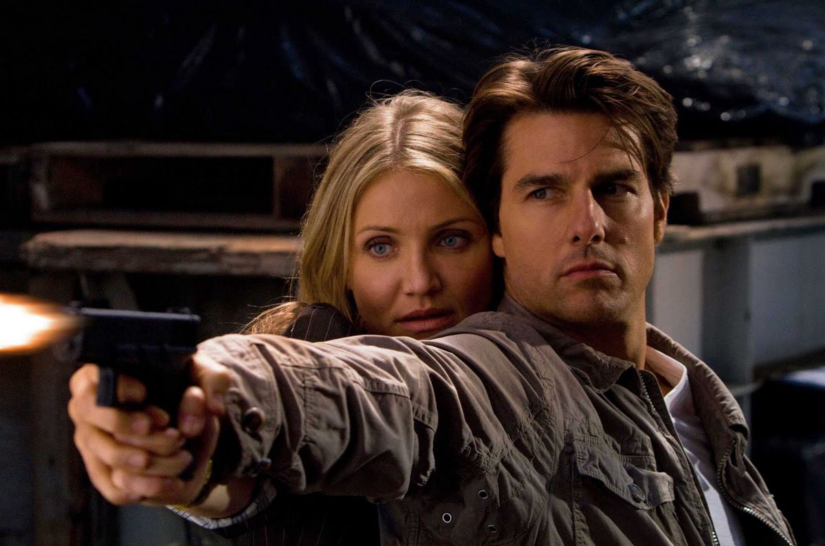 Tom Cruise e Cameron Diaz tengono insieme una pistola in Knight & Day