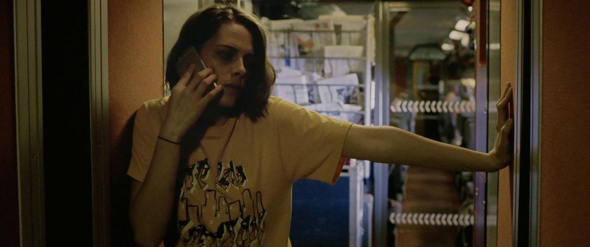 Kristen Stewart si appoggia a un muro mentre è al telefono in Personal Shopper.