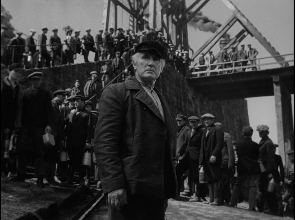 Donald Crisp nei panni di Gwilym Morgan in How Green Was My Valley, di fronte a una fila di minatori.