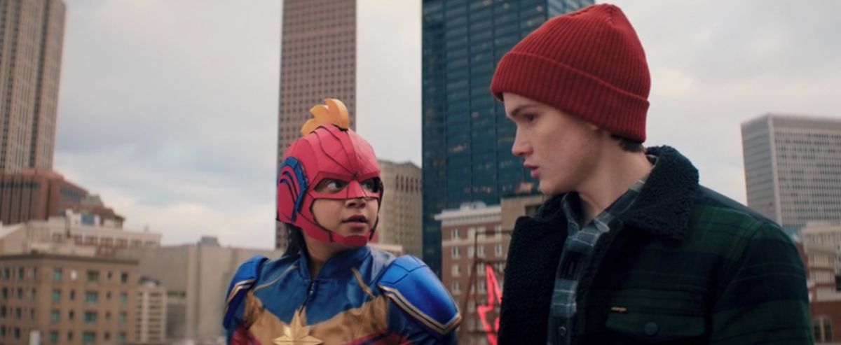 La signora Marvel e la sua amica con un berretto rosso si preparano a saltare da un edificio
