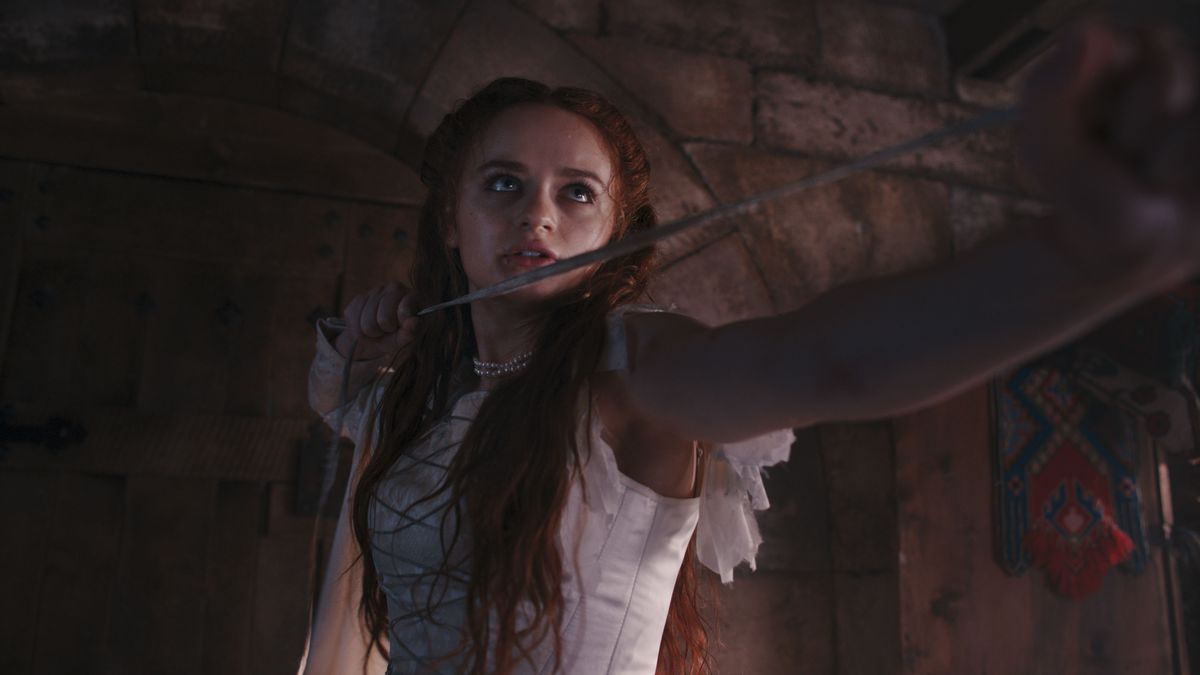 la principessa, interpretata da Joey King, in un abito bianco strappato con in mano una frusta