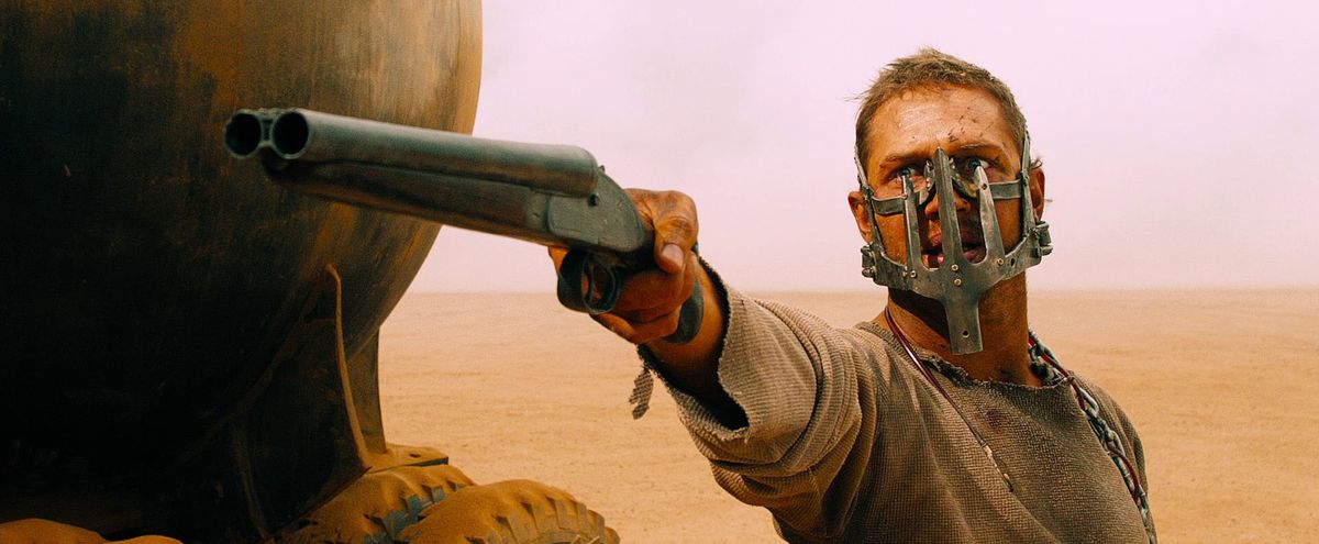 Tom Hardy, che indossa una maschera di metallo, impugna un fucile in Mad Max: Fury Road.