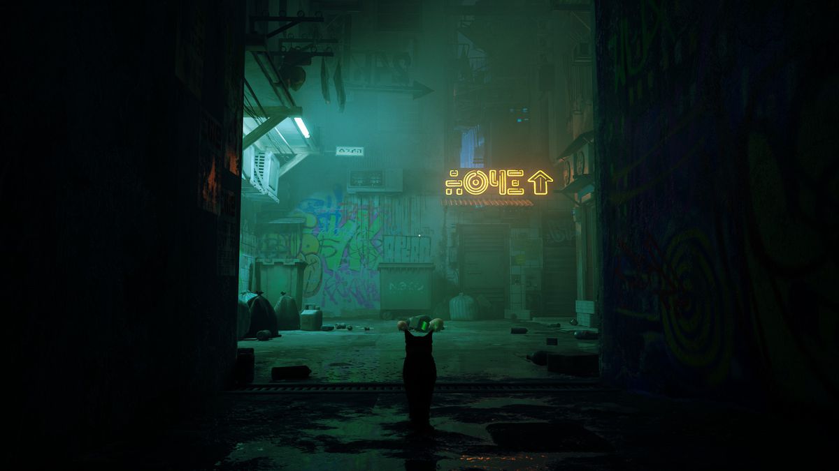 il gatto protagonista di Stray in piedi in un vicolo oscuro che guarda un muro con un'insegna al neon sopra