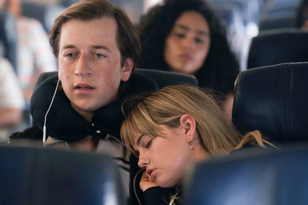 Sam sembra scioccato su un aereo mentre la sua ragazza dorme sulla sua spalla in The Resort