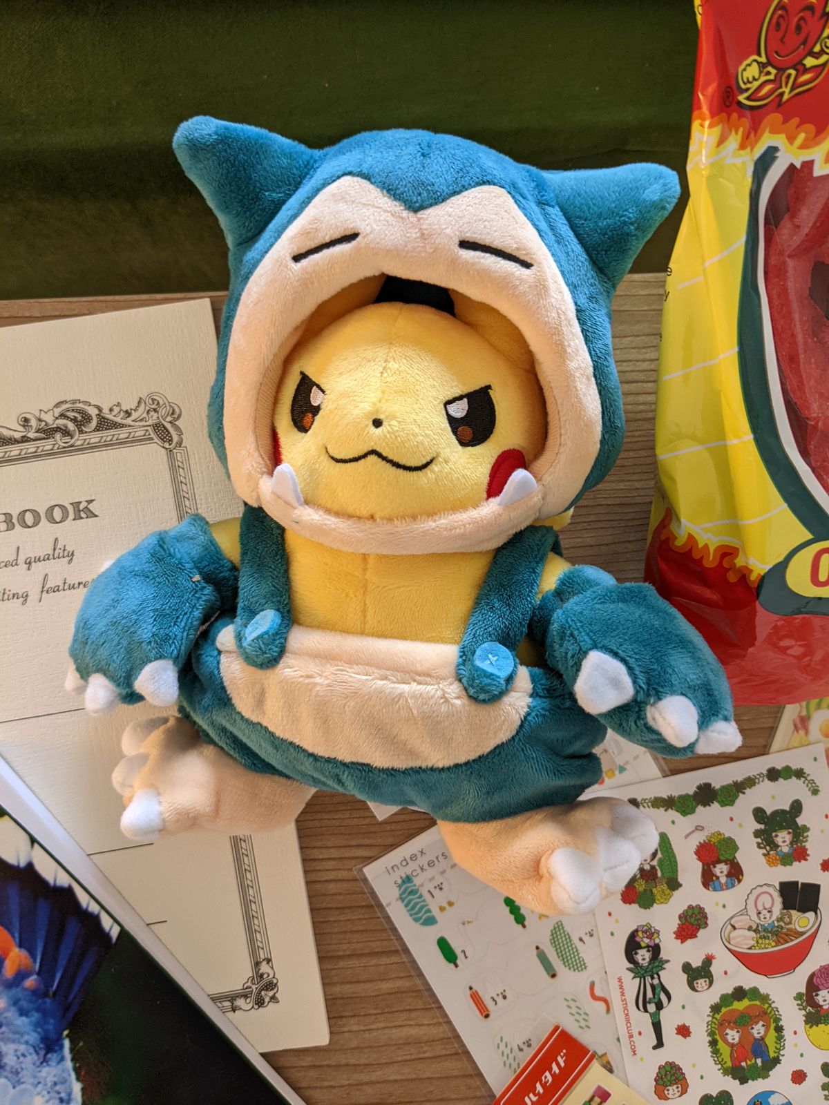 Una foto di un peluche Pikachu che indossa un costume da Snorlax