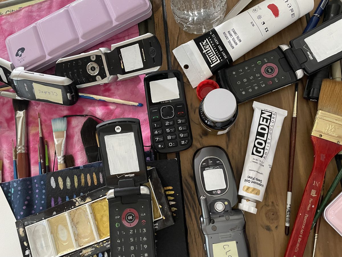 Una fotografia di pennelli e diversi vecchi telefoni cellulari