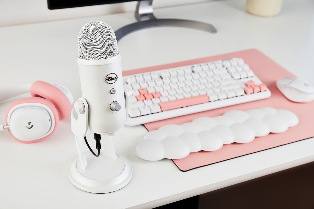 accessori rosa e bianchi color pastello, dotati di microfono bianco, tastiera bianca con accenti rosa e pad da polso a forma di nuvola
