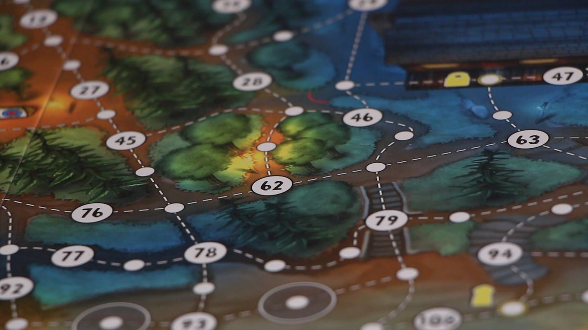 A close up image of the board from the board game Last Friday, showing trails with white dots, number dots, and campground things like cabins and forests between them.