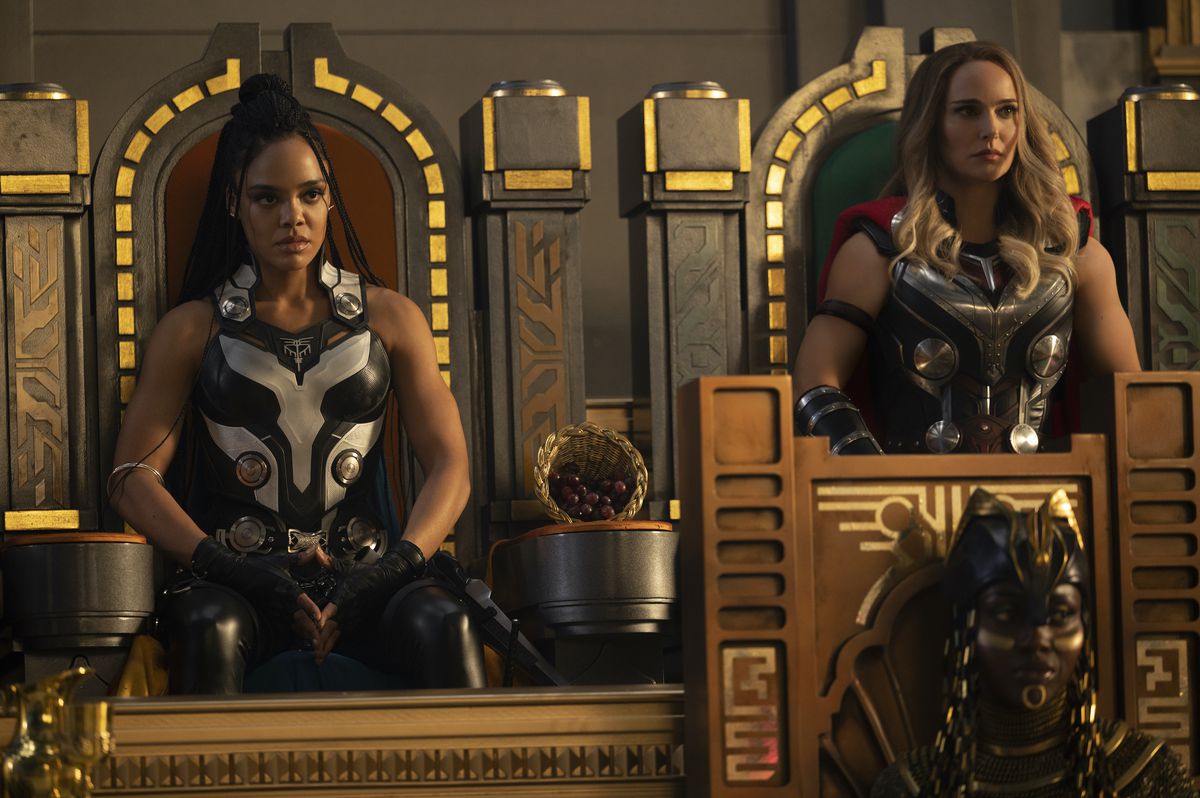 Tessa Thompson nei panni di Valkyrie e Natalie Portman nei panni di Jane Foster siedono su sedie simili a un trono in Omnipotence City in Thor: Love and Thunder