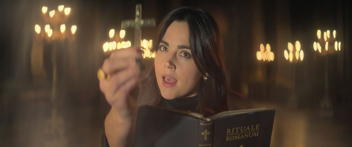Giovanna Costantino sorregge una croce e legge il Rituale