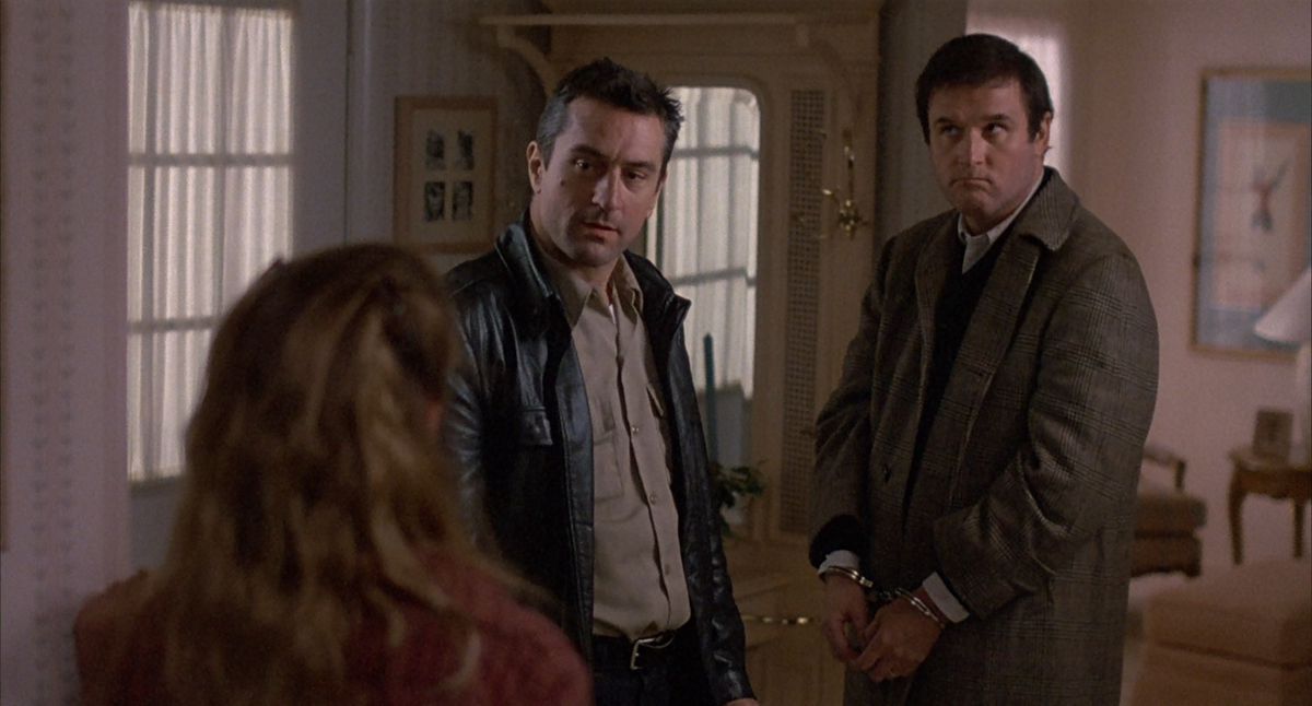 Robert De Niro è in piedi accanto a un Charles Grodin ammanettato in Midnight Run