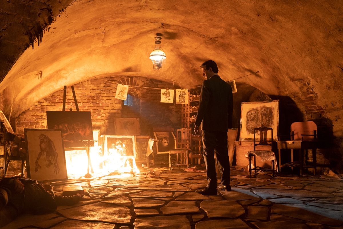 Ben Barnes nei panni di Thurber guarda i disegni spettrali in fiamme nel Gabinetto delle curiosità di Guillermo del Toro.