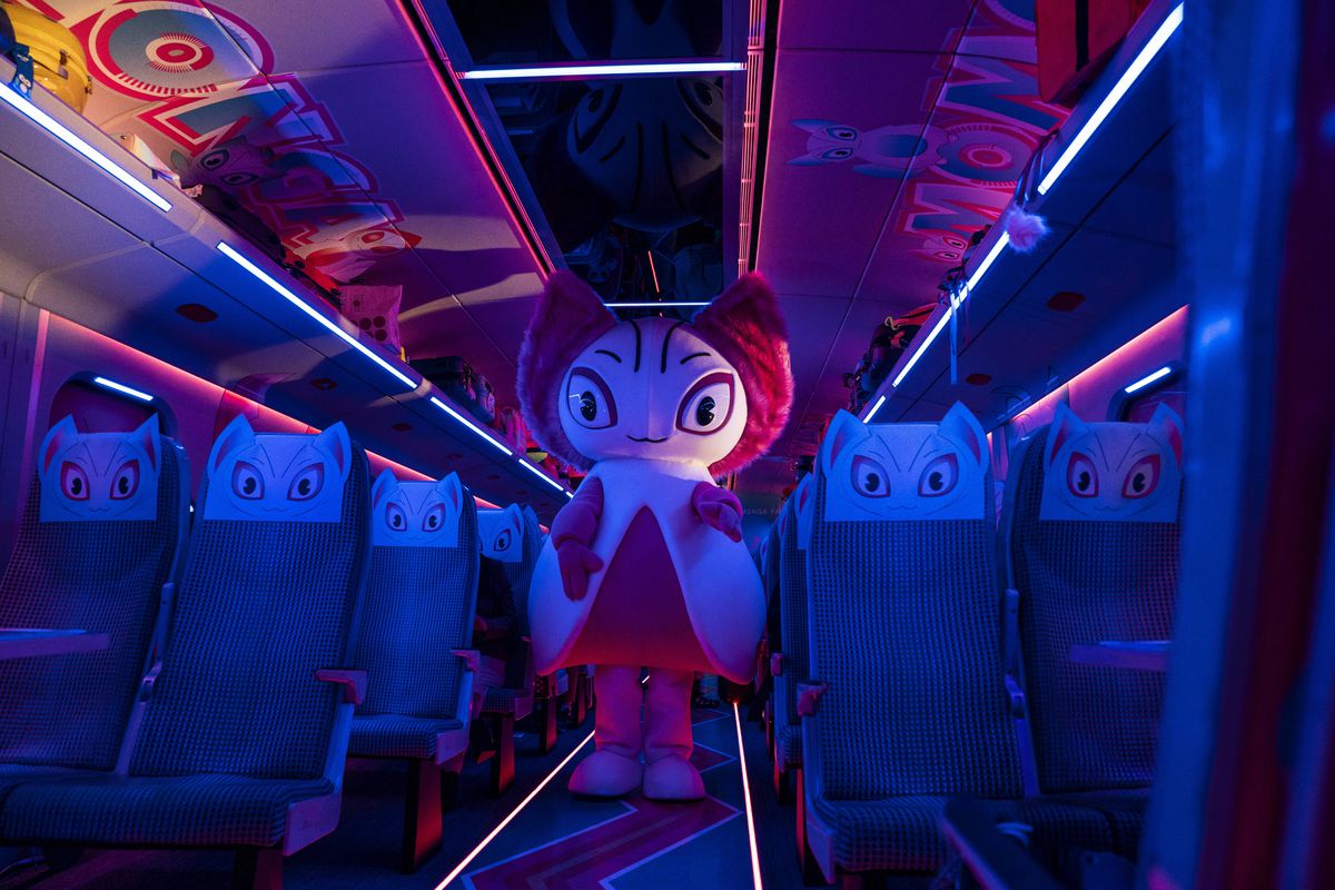 Una mascotte si trova nella passerella illuminata al neon di un'auto vuota in Bullet Train.