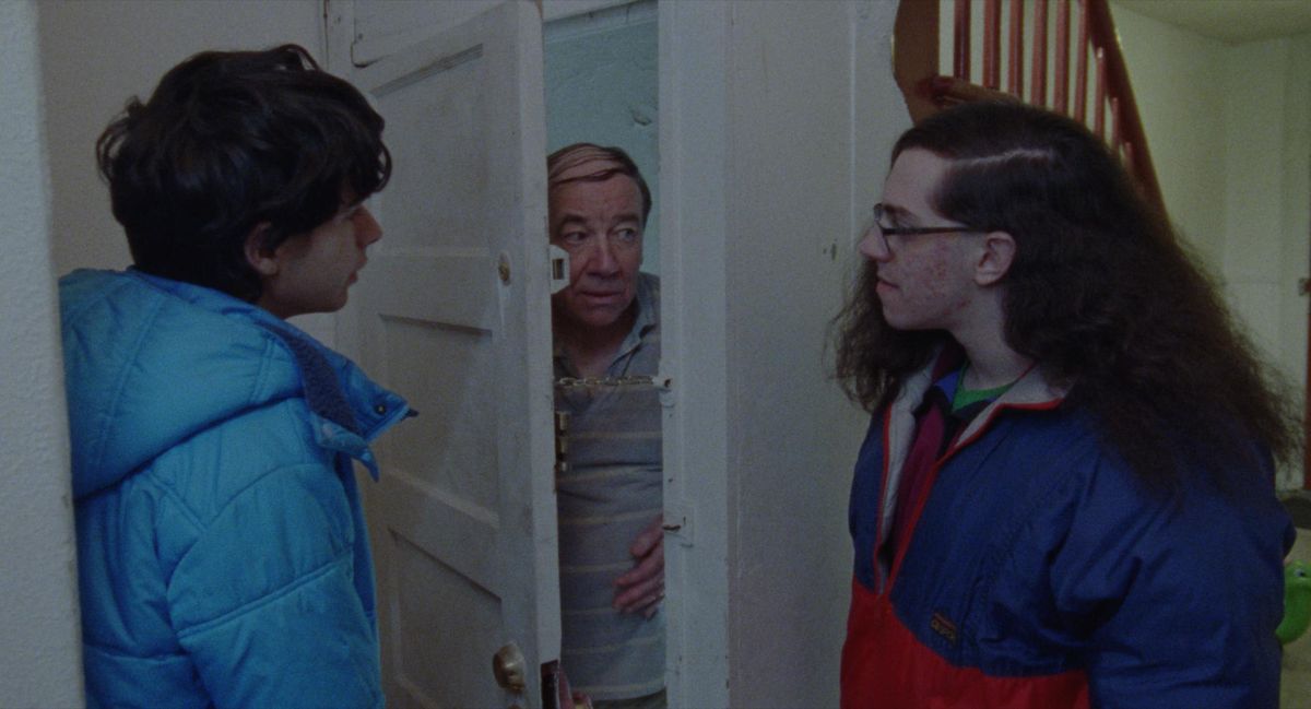 Robert e un amico stanno davanti a una porta dove un terzo uomo fa capolino cautamente in Funny Pages