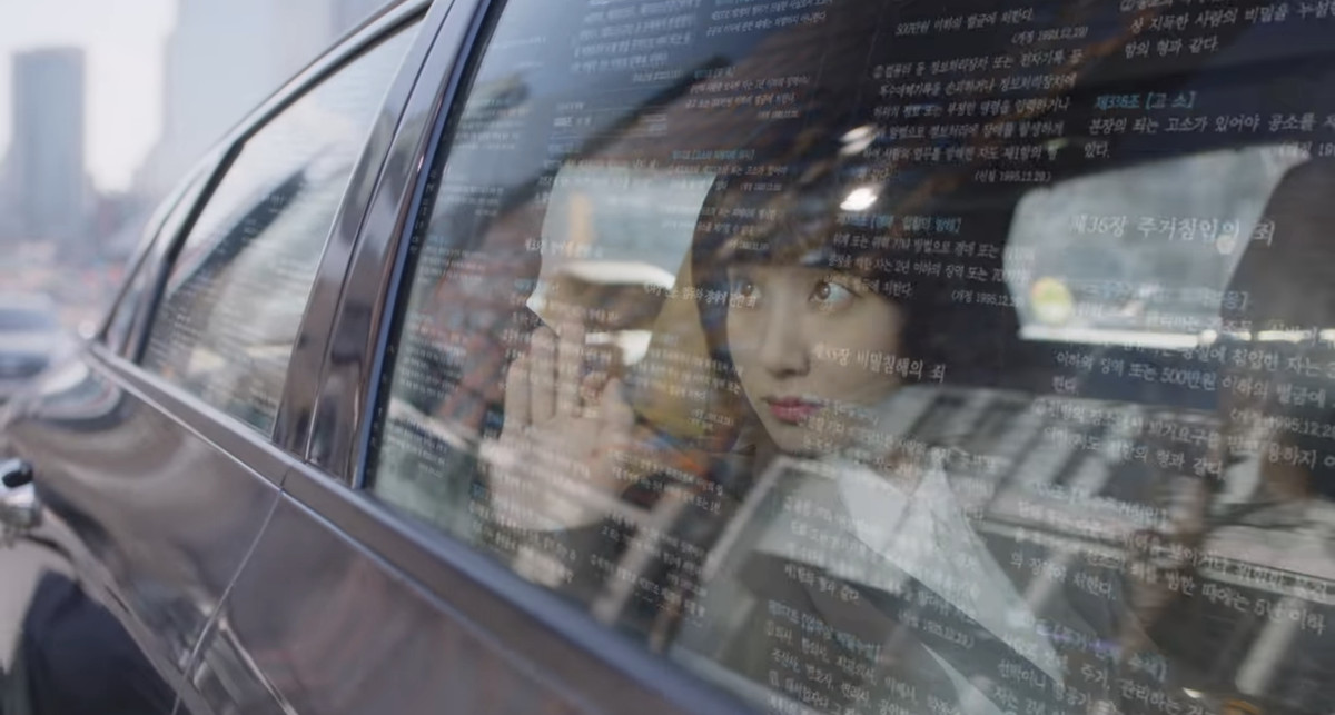Woo Young-woo immaginando fatti proiettati contro il finestrino di un'auto, si allunga per toccarli