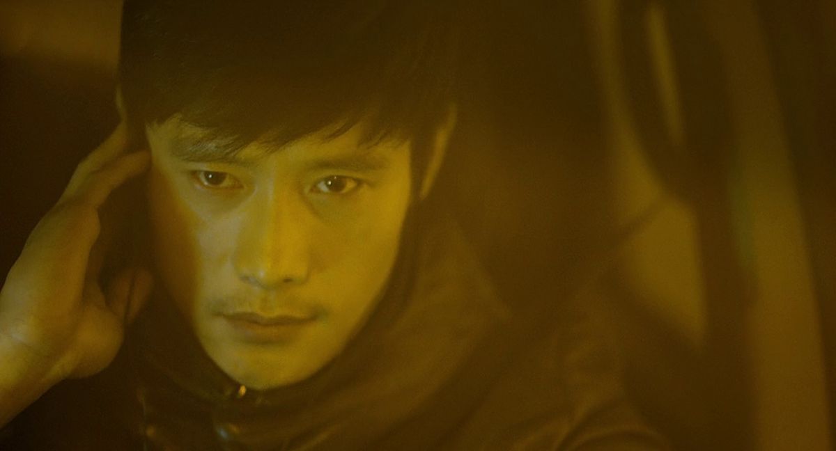 Lee Byung-hun si porta la mano destra all'orecchio e sembra molto serio in I Saw the Devil.
