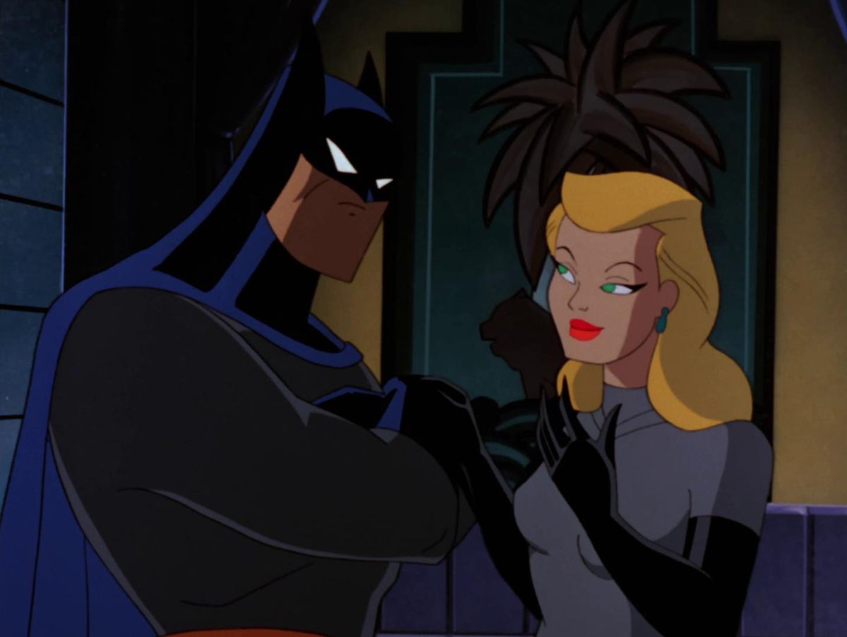Batman incrocia le braccia e fissa Selina Kyle (alias Catwoman) senza maschera in 