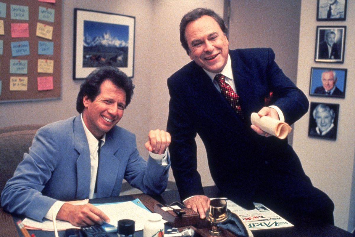 Garry Shandling e Rip Torn sorridono su una scrivania ingombra in The Larry Sanders Show.