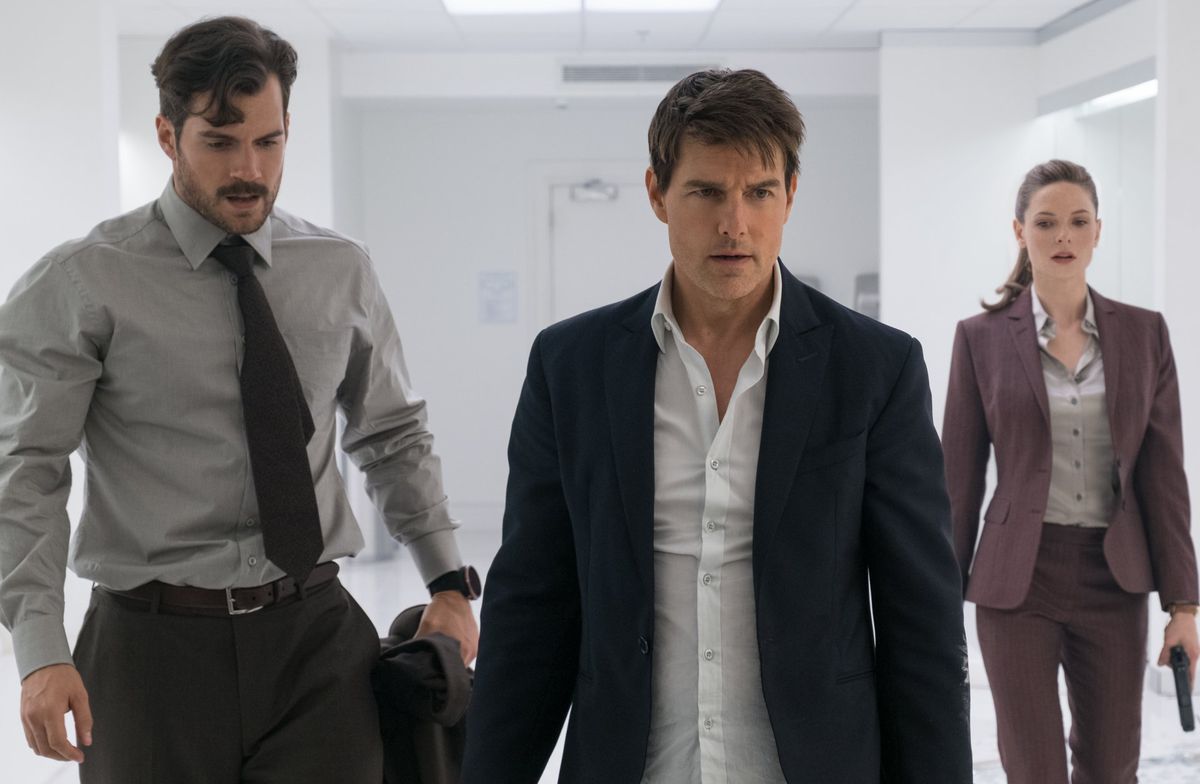 Henry Cavill, Tom Cruise e Rebecca Ferguson indossano bei vestiti e camminano in una stanza bianca in missione impossibile