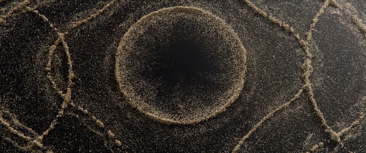 Un'inquadratura ravvicinata di una sabbia che si piega e si forma in motivi circolari.