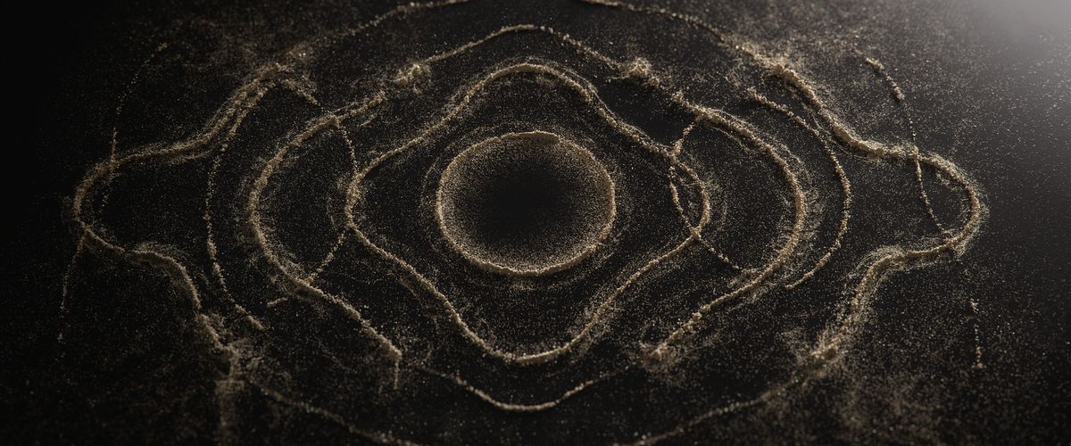 Un'ampia inquadratura di cerchi concentrici e increspati formati da sabbia e polvere.