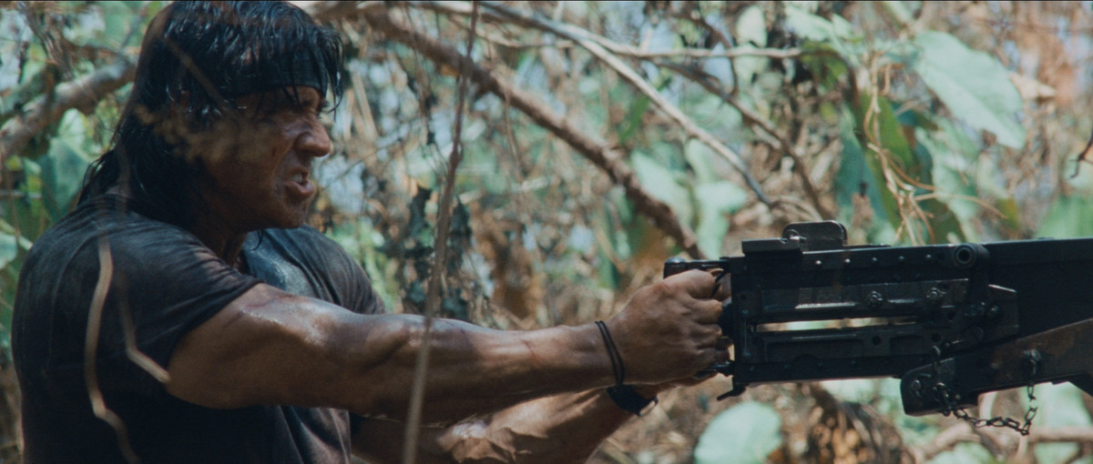 Sylvester Stallone spara con una mitragliatrice in un'area forestale a Rambo