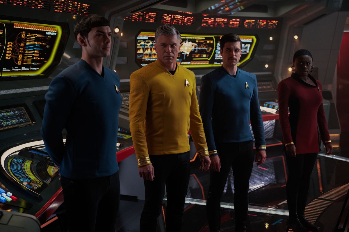 Spock in piedi con le braccia dietro la schiena sul ponte, mentre Pike, Kirk e Uhura lo guardano di lato