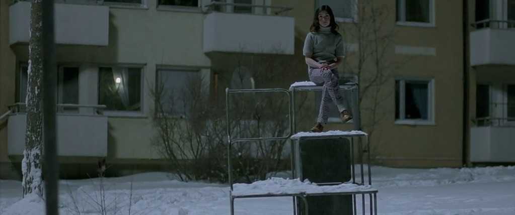 Lina Leandersson siede su una scultura congelata in Let the Right One In.