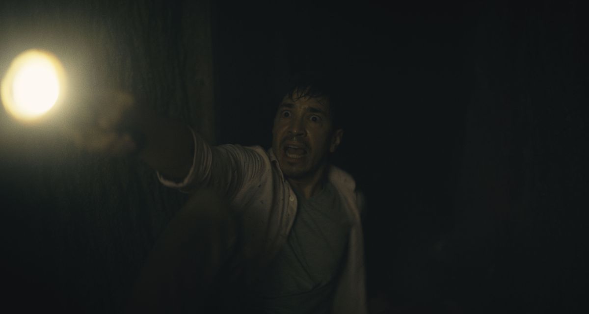 AJ, interpretato da Justin Long, brandisce una torcia in un tunnel molto buio in Barbarian.