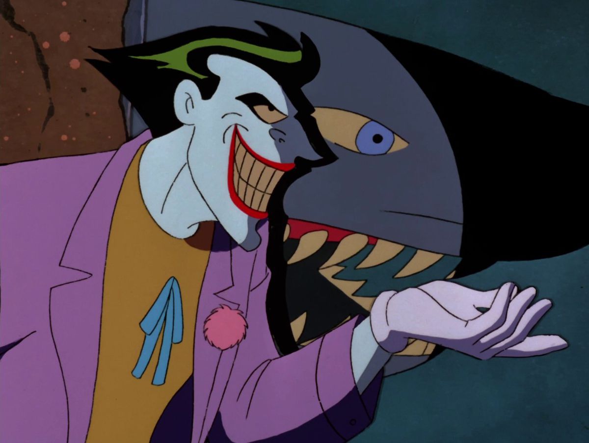 Joker in piedi accanto a uno squalo in una vasca in 