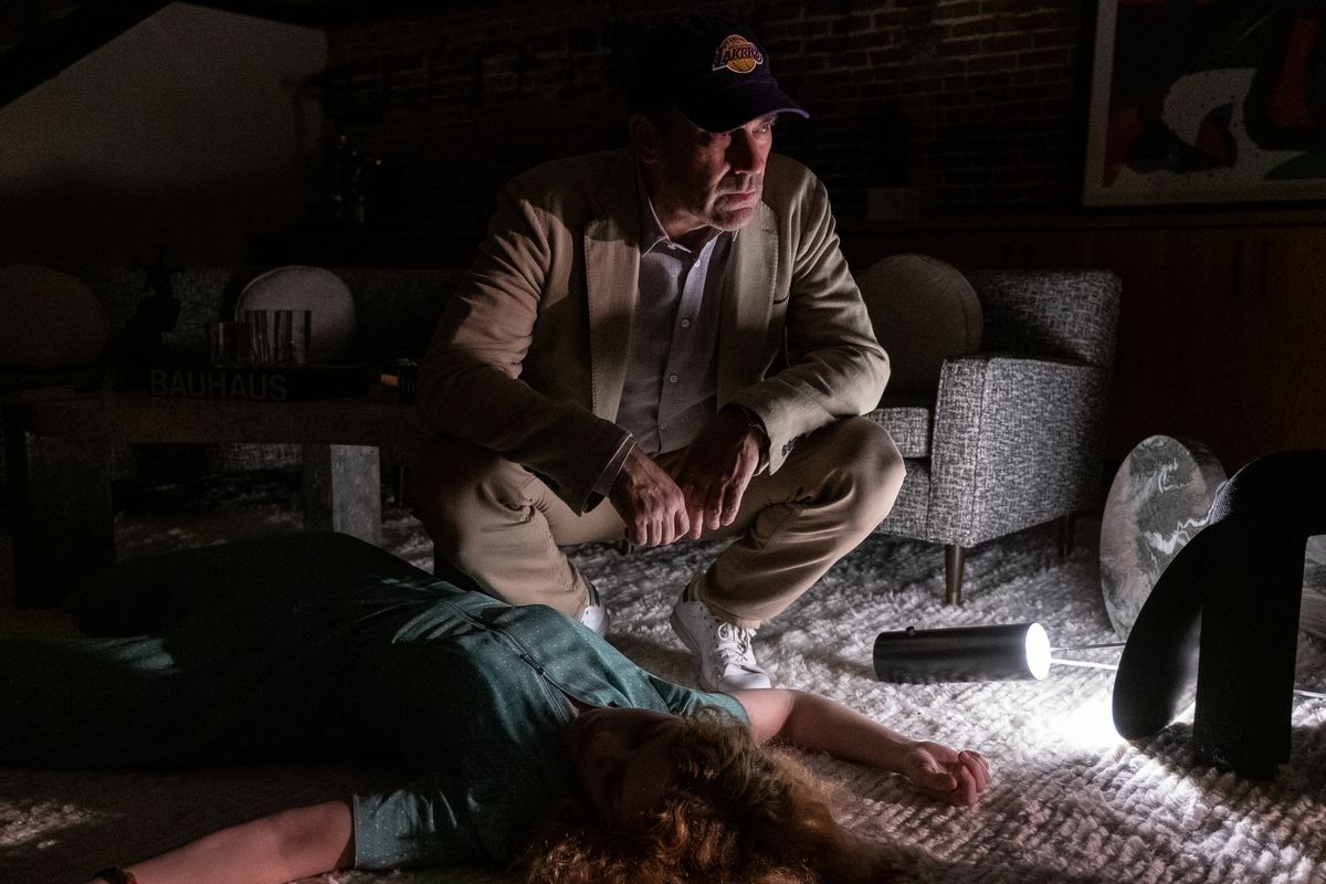 Fletch (Jon Hamm) si accovaccia sul cadavere di una donna inaspettata nel suo appartamento a Confess, Fletch