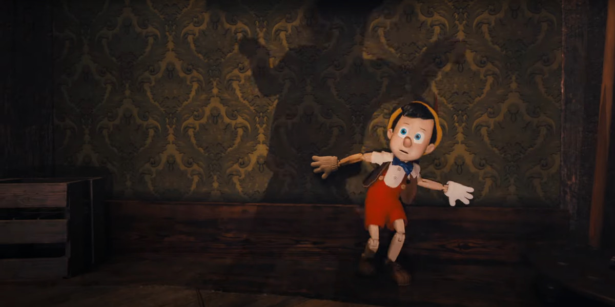 Pinocchio che si rannicchia per la paura di una minaccia invisibile nel film Pinocchio di Disney Plus