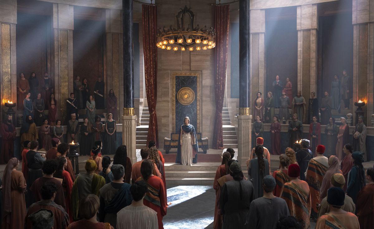 La regina reggente di Numenor in piedi davanti alla gente nella sala del trono;  ci sono persone in piedi in fila di fronte a lei, oltre a fiancheggiarla sui deis