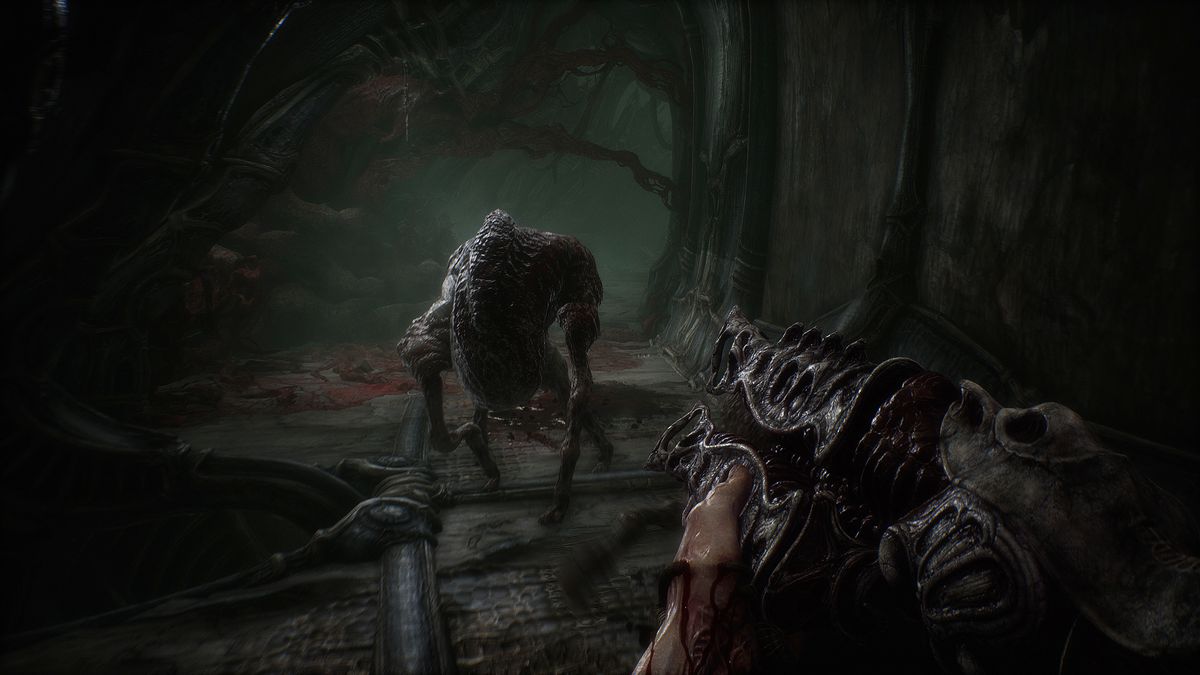 Il personaggio del giocatore punta il fucile dall'aspetto gotico verso un mostro che si avvicina a loro in Scorn