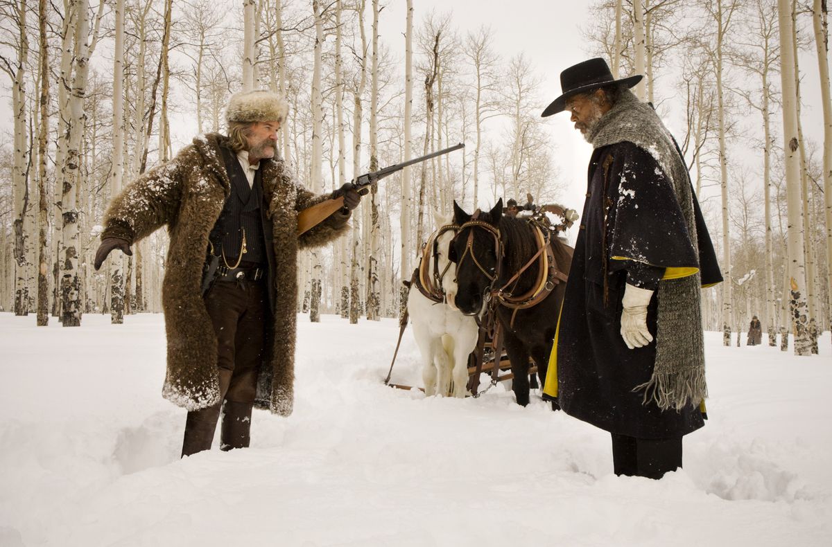John Ruth (Kurt Russell) e il marchese Warren (Samuel L. Jackson) si confrontano in un campo innevato, con due cavalli che guardano, in The Hateful Eight