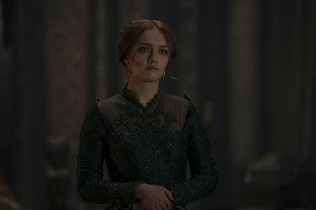 Olivia Cooke, vestita di verde, unisce le mani in House of the Dragon.