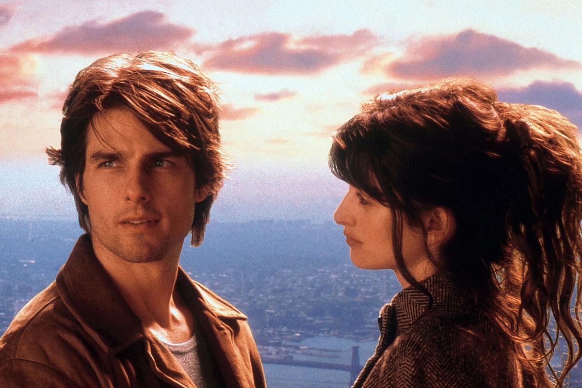 Un uomo (Tom Cruise) distoglie lo sguardo da una donna (Penélope Cruz) mentre si trova di fronte a un tramonto idilliaco con uno skyline di New York in lontananza.