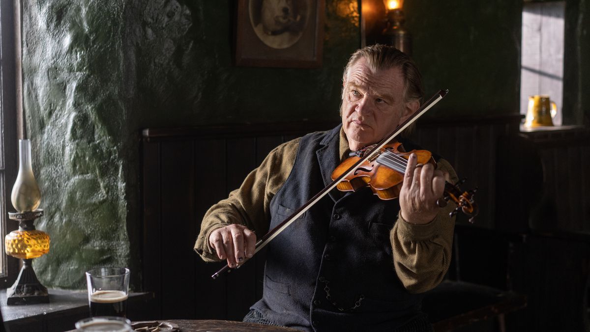 Colm (Brendan Gleeson) suona il violino a un tavolo nel pub locale in The Banshees of Inisherin