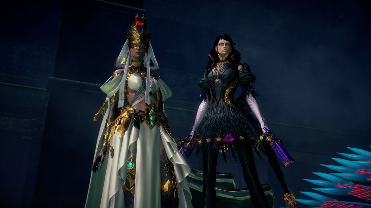 Una Bayonetta di un altro universo (a sinistra), che indossa un abito bianco di ispirazione egizia e gioielli d'oro, si trova accanto alla Bayonetta del nostro universo (a destra), vestita di nero