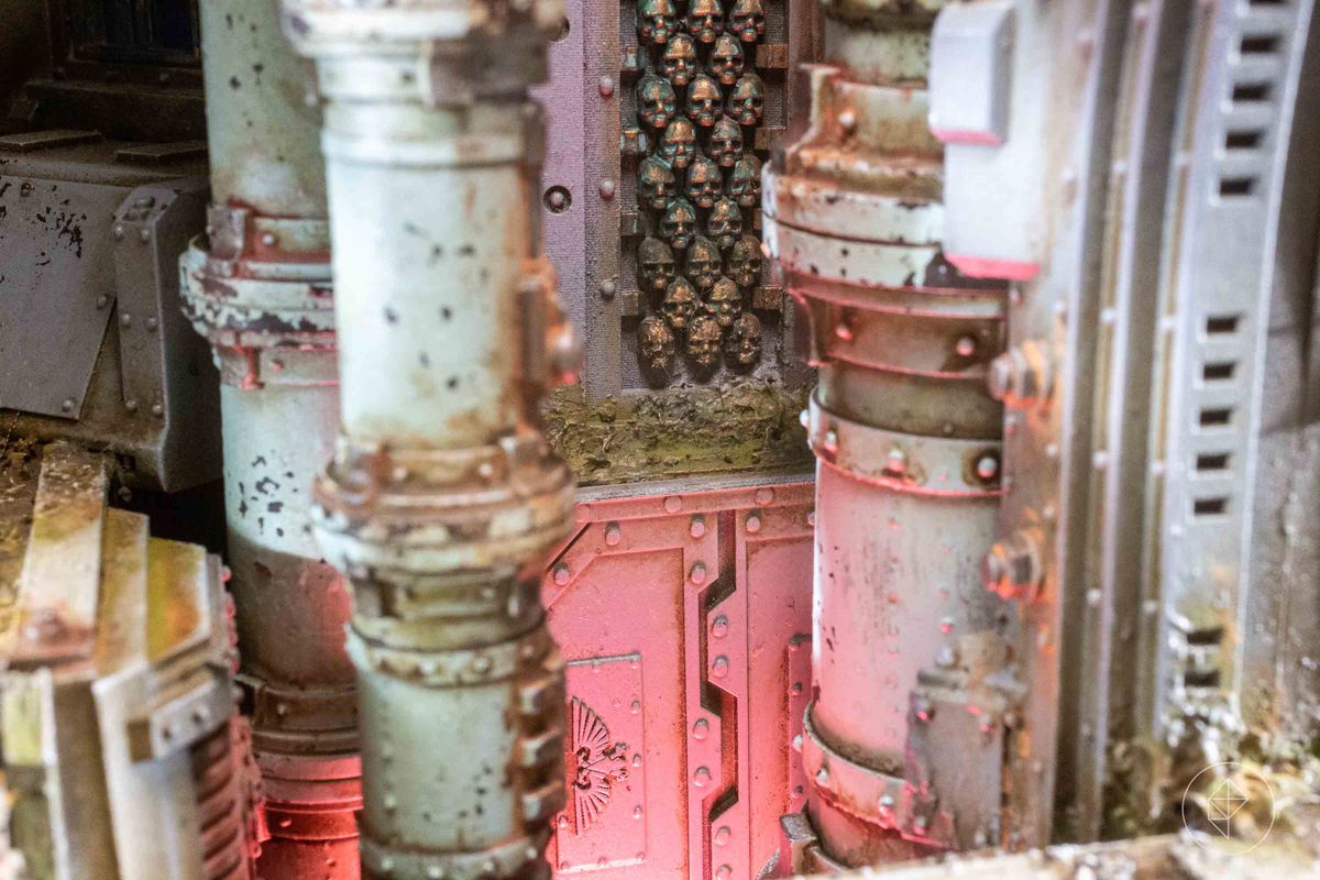 Dettagli di un'astronave gotica.  La telecamera ingrandisce i tubi distrutti del passato, sopra un minaccioso bagliore rosso, fino alle ossa della stanza stessa, che è costruita con teschi.