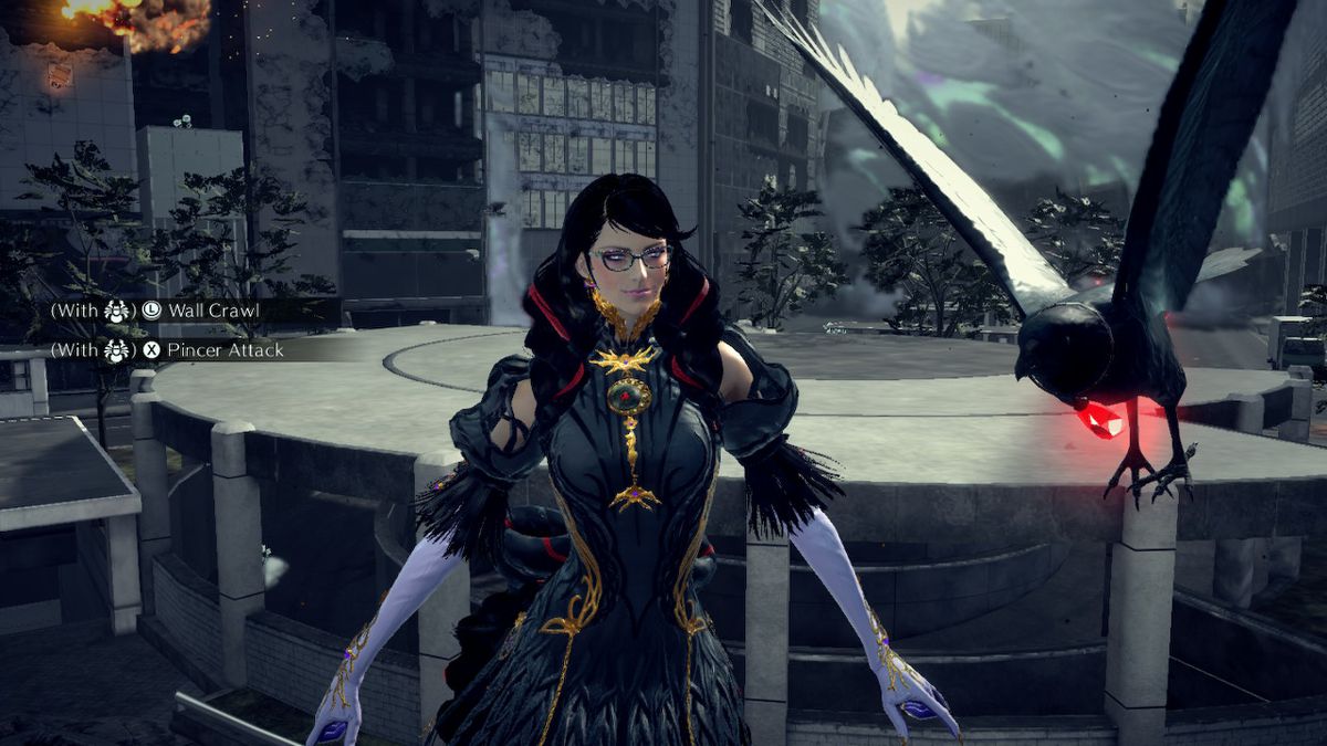 Bayonetta è in piedi di fronte a un corvo con in mano un gioiello rosso