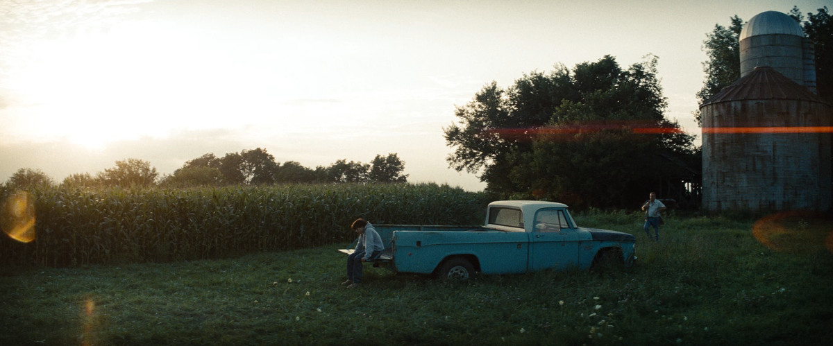 Un giovane Clark Kent siede sul retro di un camioncino in Man of Steel, con Kevin Costner che si avvicina dalla parte anteriore del camion.