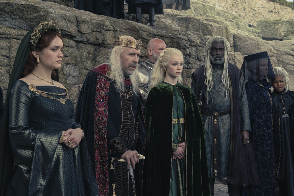 Alicent, Viserys, Rhaenyra e Corlys vengono radunati davanti a una scogliera in abiti funebri durante una commemorazione nella Casa del Drago.