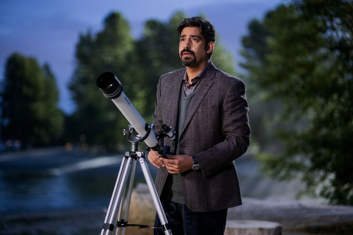 Vincent, interpretato da Rahul Kohli, in piedi dietro un telescopio a guardare il cielo in The Midnight Club di Netflix