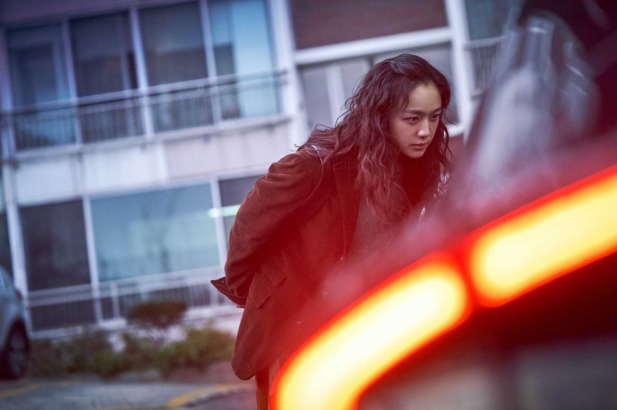 Seo-rae (Tang Wei) guarda attraverso il finestrino di un'auto in un parcheggio in Decision to Leave