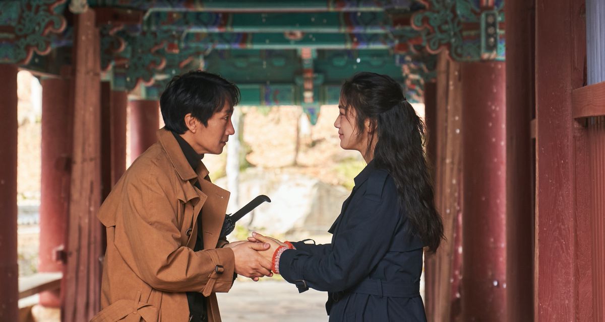 Hae-jun (Park Hae-il) e Seo-rae (Tang Wei) si tengono per mano in un tempio in un raro momento di connessione fisica in Decision to Leave